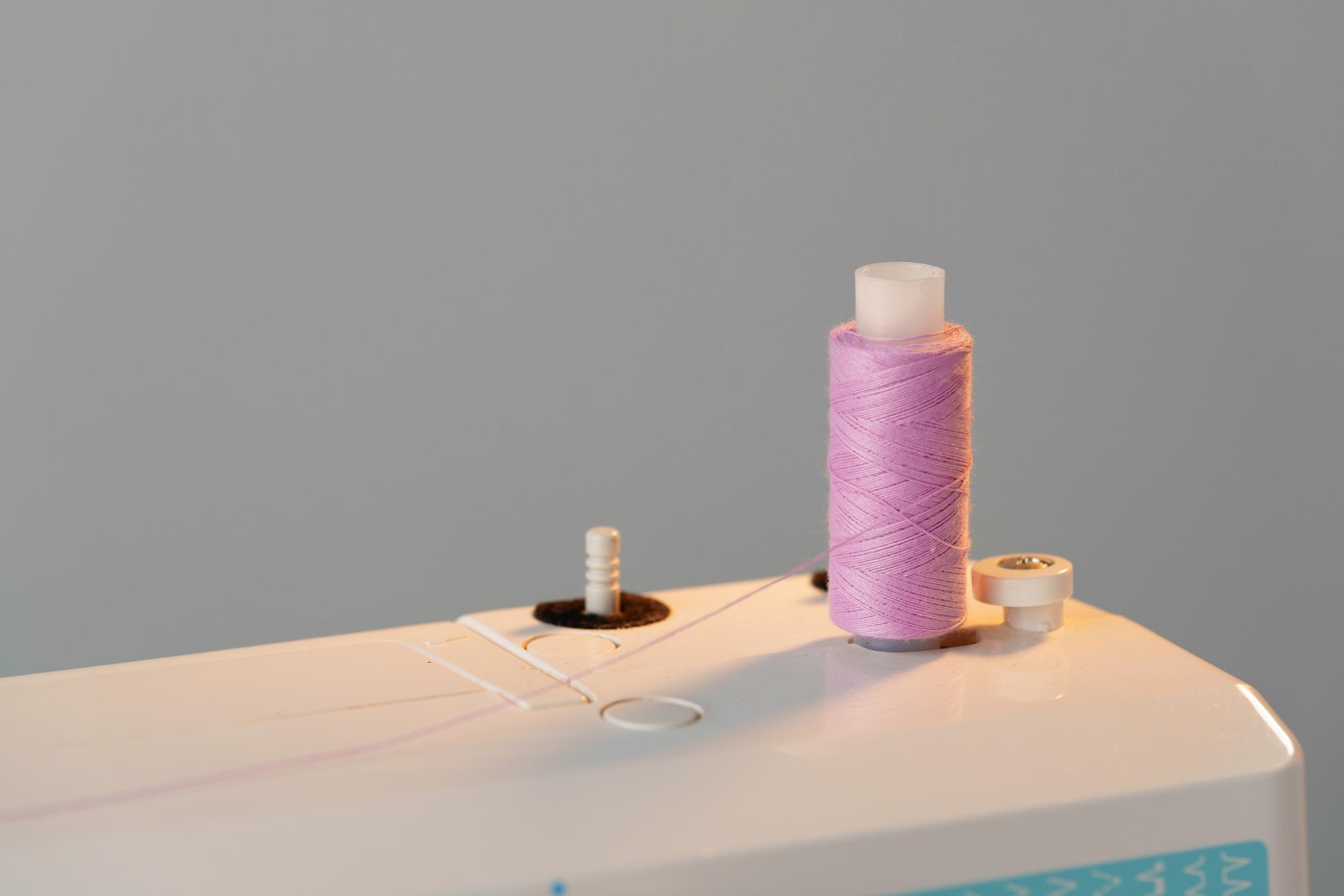 workspace table with spools of thread and stitched sample