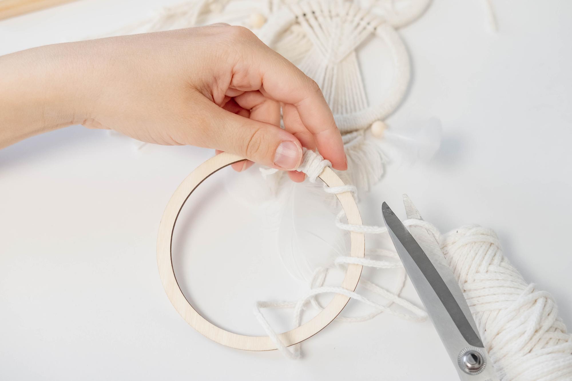 close-up of hand-guided embroidery hoop with neutral threads